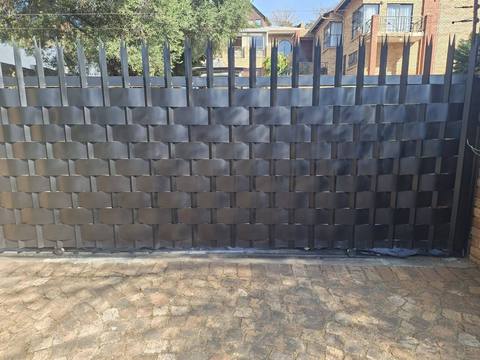 Close-up of steel slats woven through an existing gate
